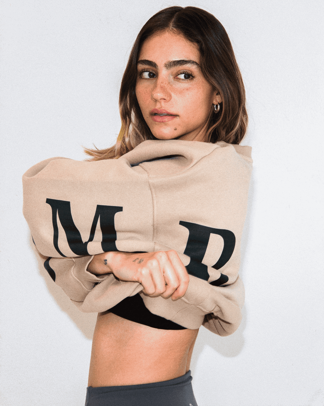 Woman wearing oversized beige LOGO sweatshirt with AM RADIO print