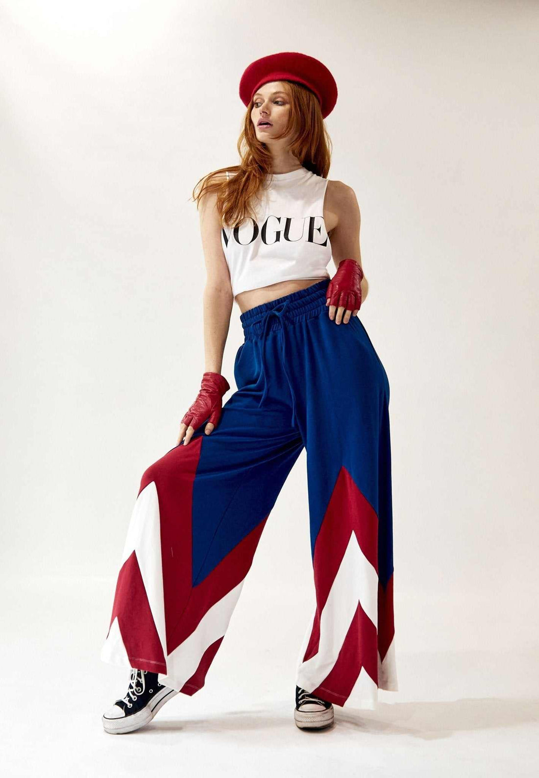 Model wearing AM Wide-Leg Color Block Pant in blue, red, and white with elastic waist and drawstring, styled with cropped white Vogue top and red accessories.