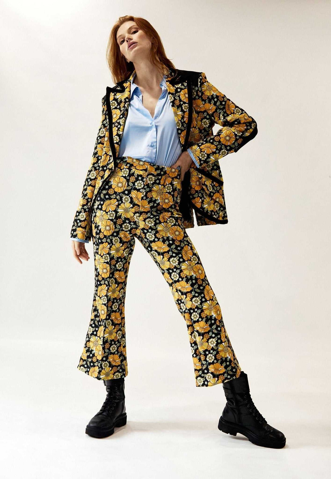 Model wearing Woodstock Floral Pintuck Retro Flair Pant with cropped hem and contrast velvet taping paired with matching blazer and black boots