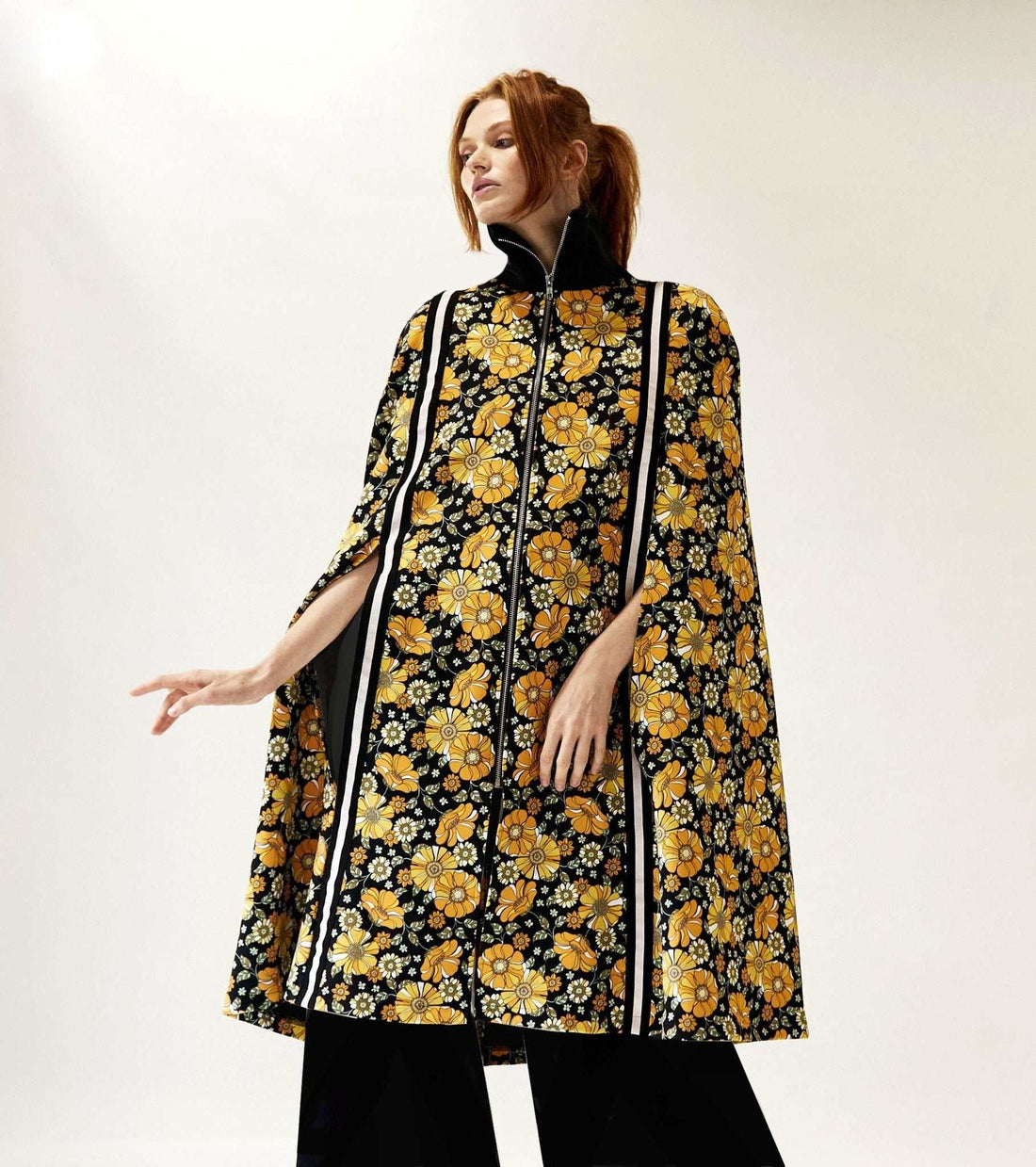 Gender neutral floral patterned cape with hidden arm holes and contrast tape detailing